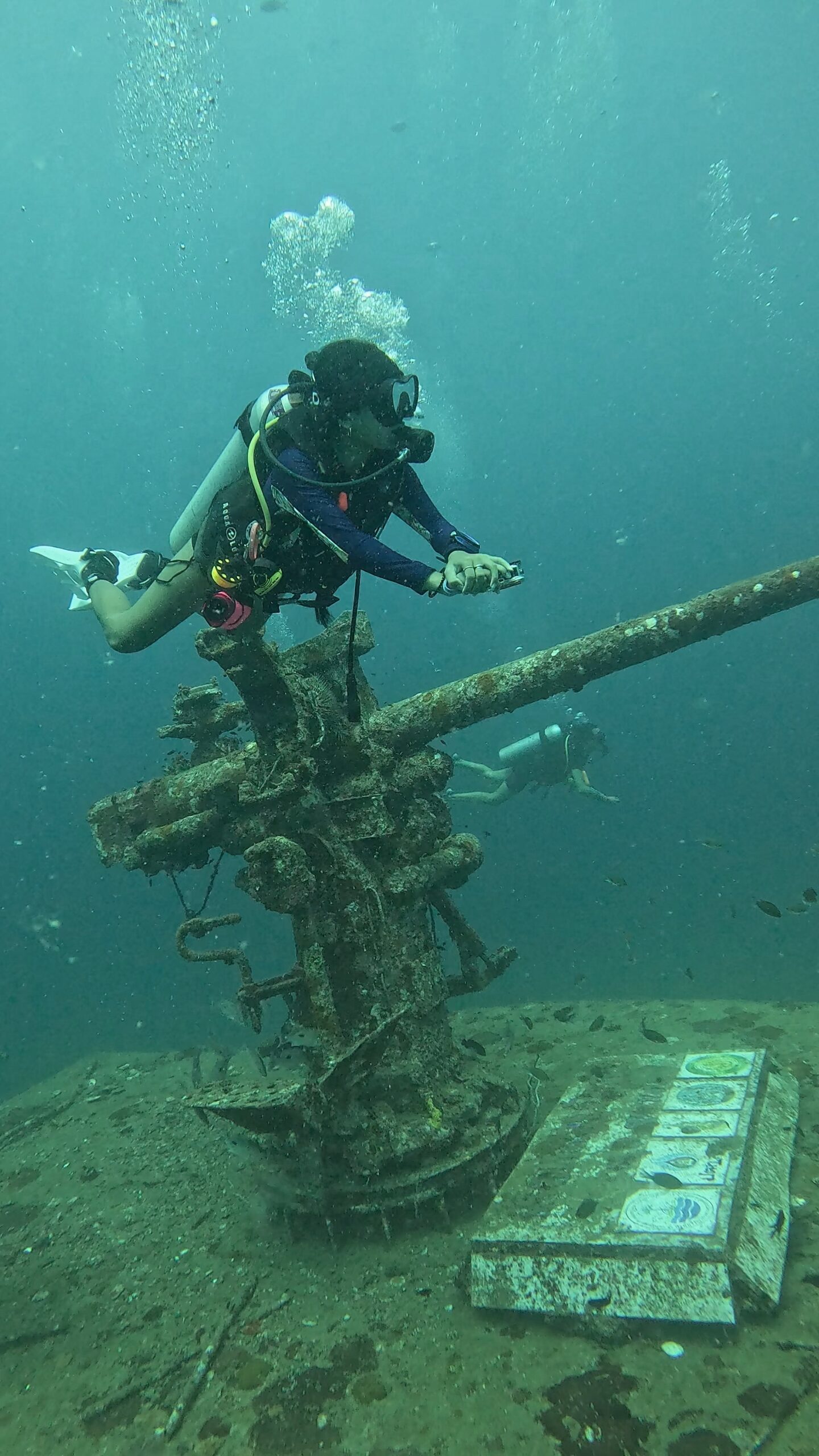 Diver posing above the deck gun on the Sattakut wreck in Koh Tao, Thailand