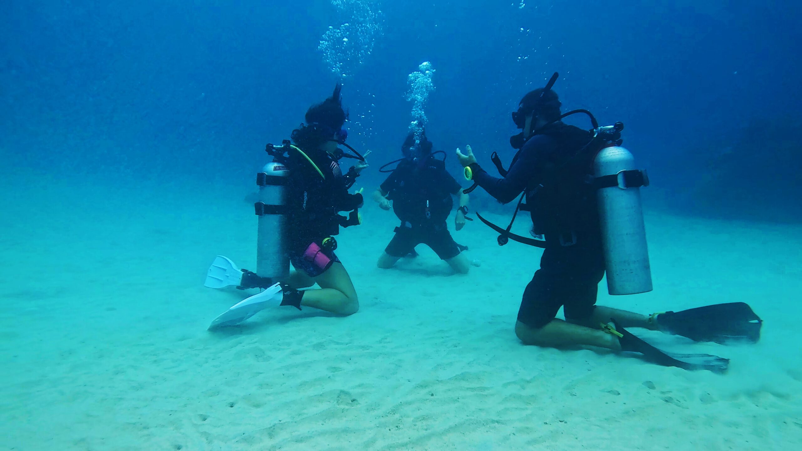 Scuba diving instructor teaching two students underwater during an Open Water course in Koh Tao – small group scuba training with Dive In Koh Tao.