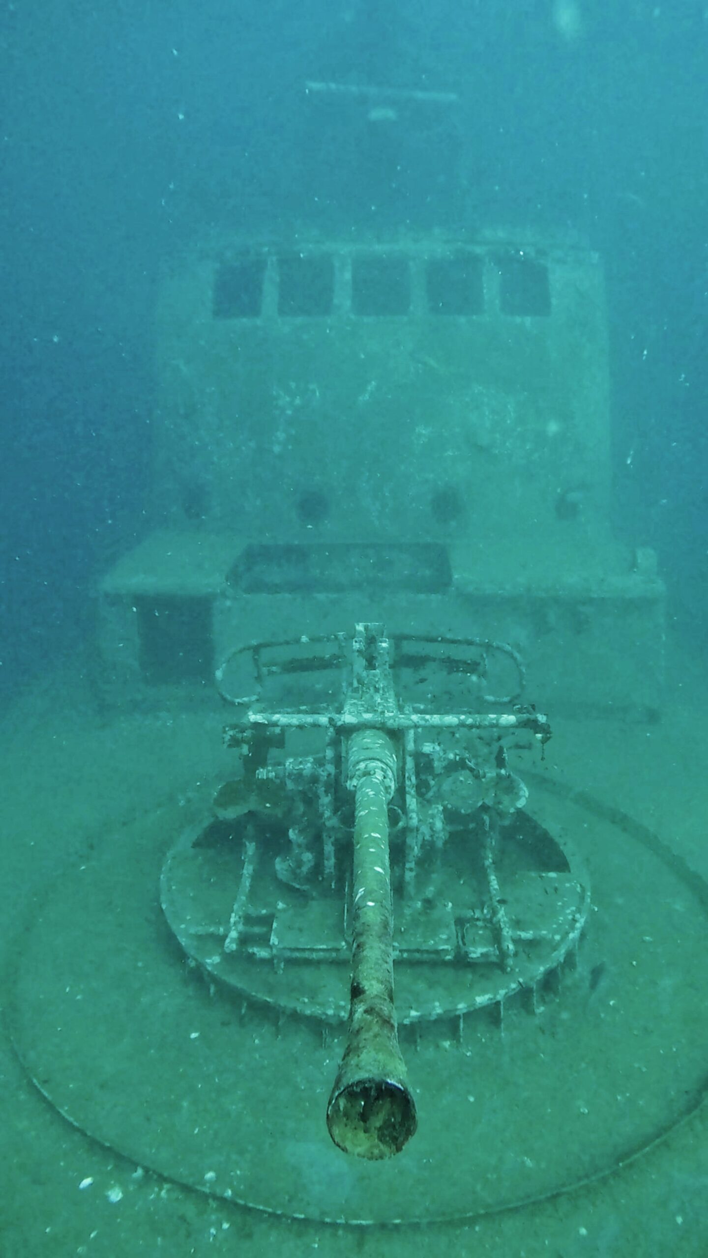 HTMS Sattakut shipwreck at Koh Tao, Thailand, showing deck gun and bridge structure, popular site for wreck diving and underwater photography.