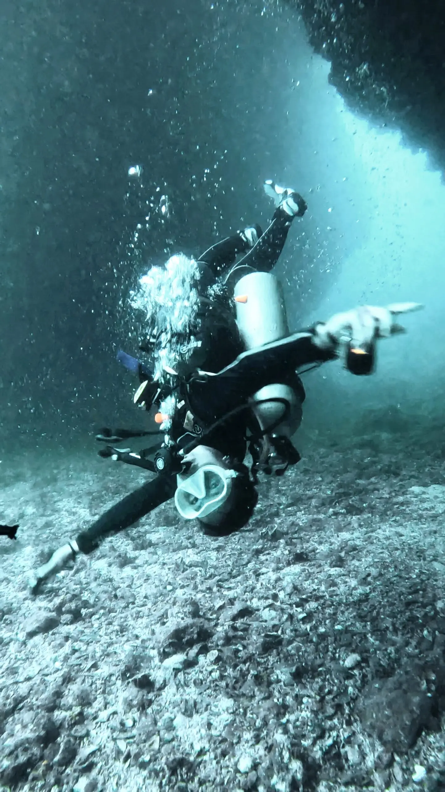 Scuba diver underwater at depth during a Deep Diving Specialty dive in Koh Tao, showing playful movement that highlights the effects of depth and narcosis awareness training.