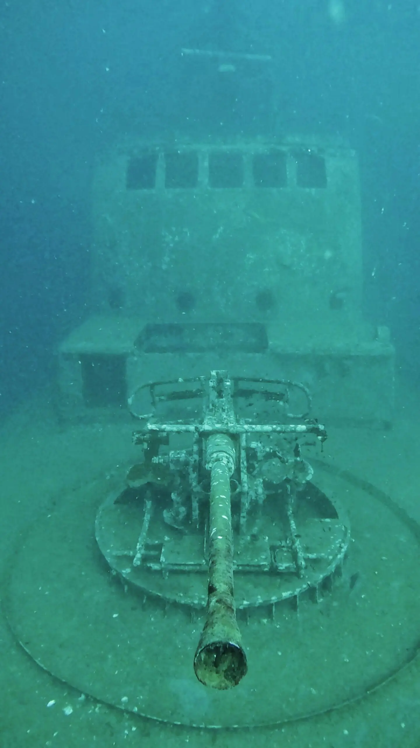 HTMS Sattakut shipwreck at Koh Tao, Thailand, showing deck gun and bridge structure, popular site for wreck diving and underwater photography.