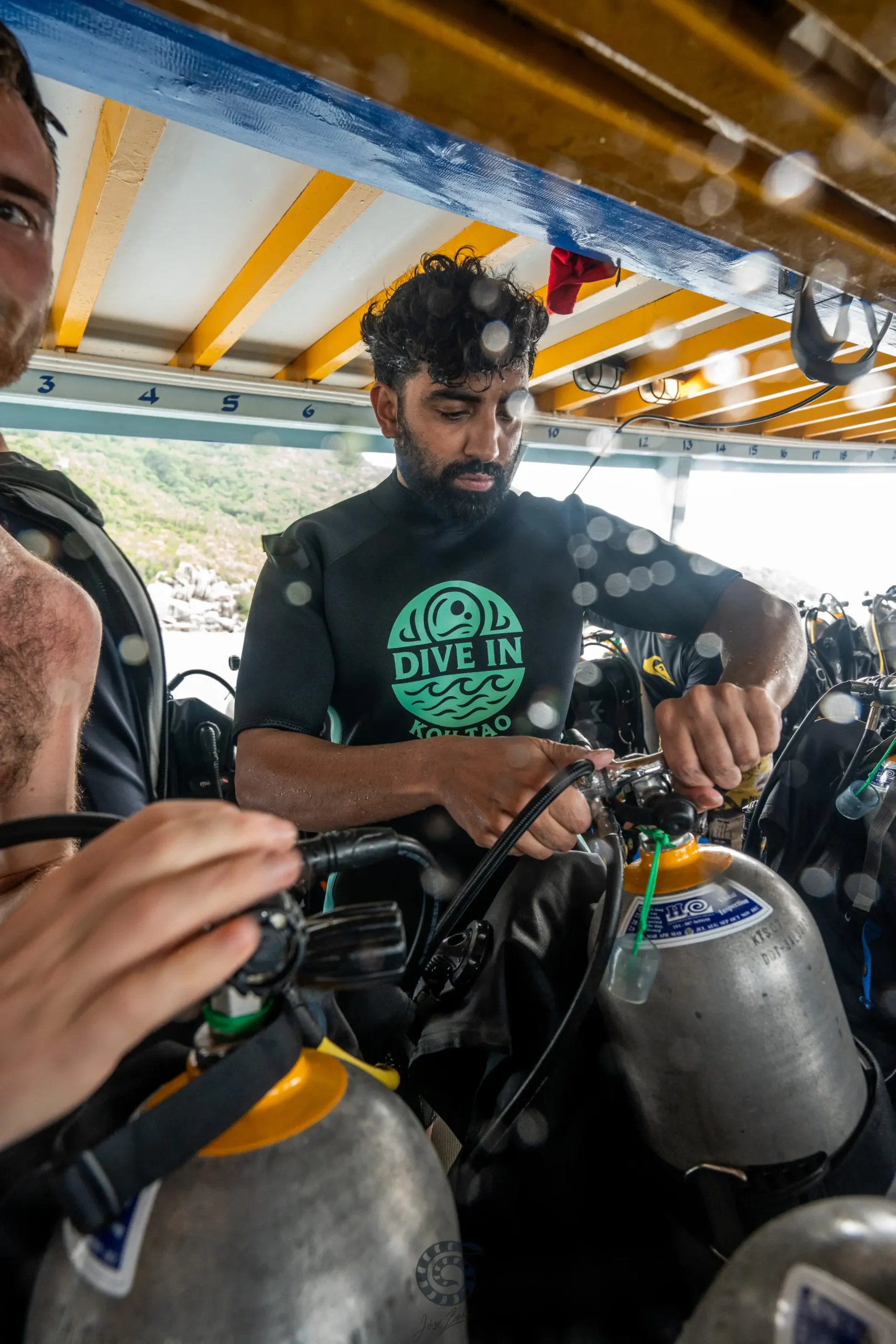 Scuba diver preparing diving equipment on a boat before a scuba diving trip in Koh Tao, Thailand