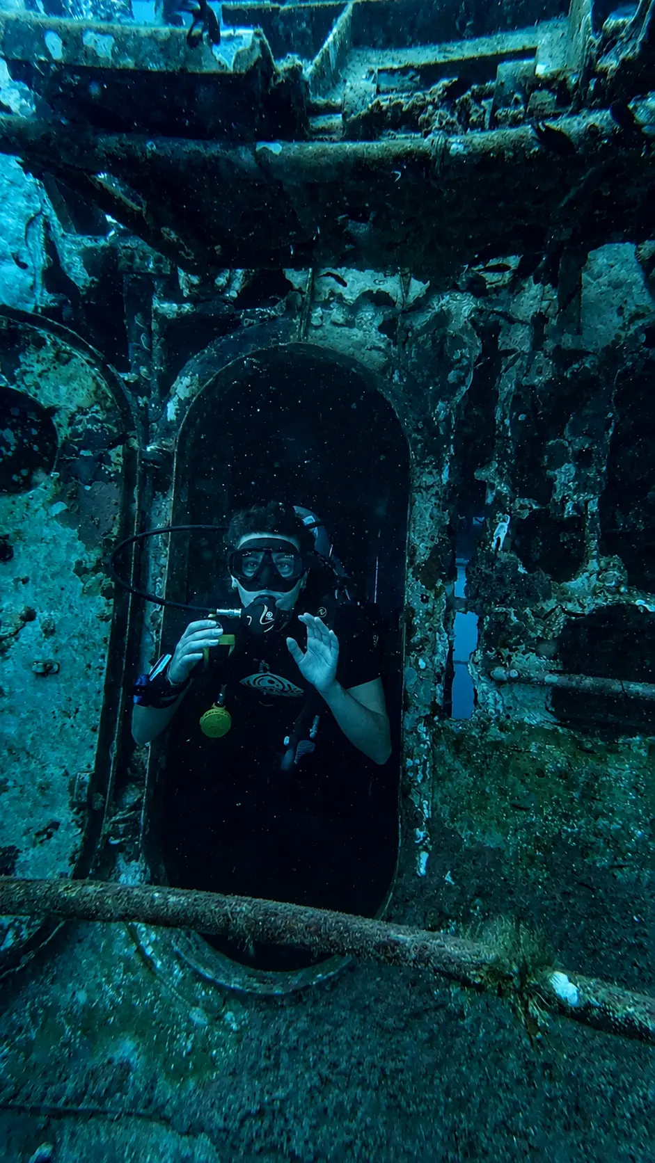 Scuba diver at the entrance of a shipwreck swim-through during an SSI Wreck Diving specialty dive in Koh Tao, Thailand.